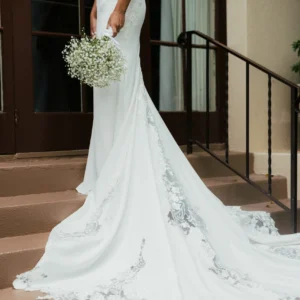 Elegancka koronkowa suknia ślubna typu fit & flare na cienkich ramiączkach z wycięciem i trenem