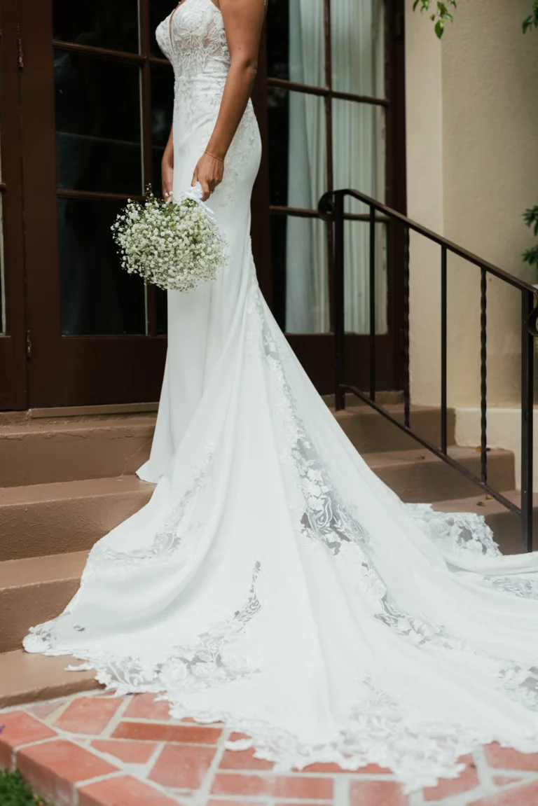 Elegancka koronkowa suknia ślubna typu fit & flare na cienkich ramiączkach z wycięciem i trenem