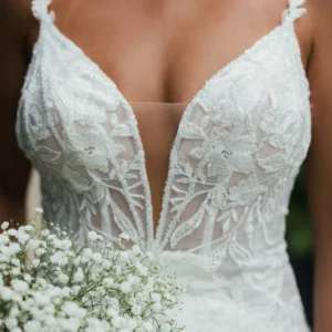 Elegancka koronkowa suknia ślubna typu fit & flare na cienkich ramiączkach z wycięciem i trenem