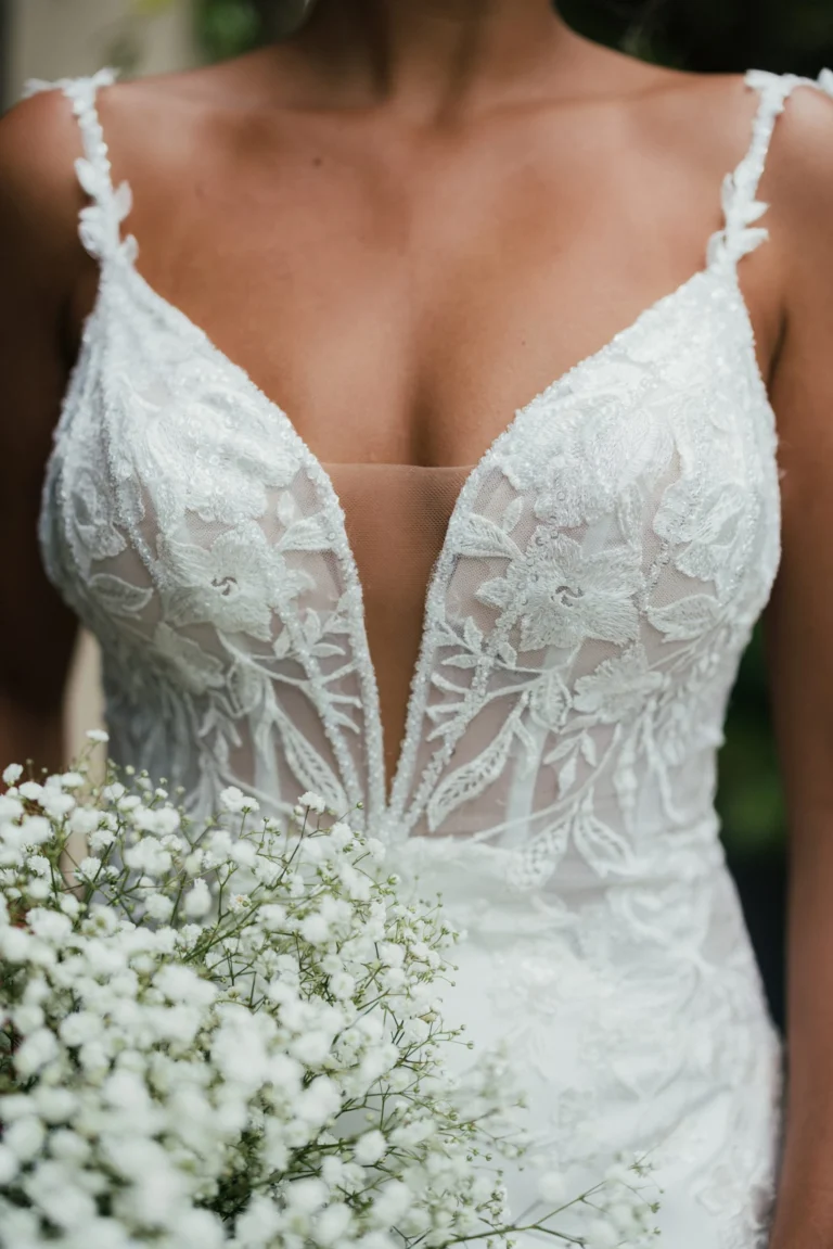 Elegancka koronkowa suknia ślubna typu fit & flare na cienkich ramiączkach z wycięciem i trenem