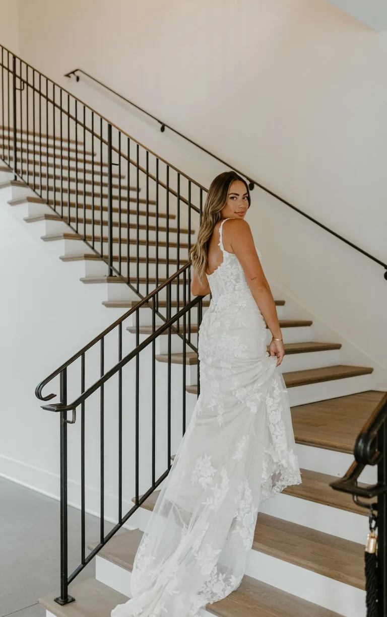 Elegancka koronkowa suknia ślubna typu fit & flare z kwiatowym motywem i ramiączkami