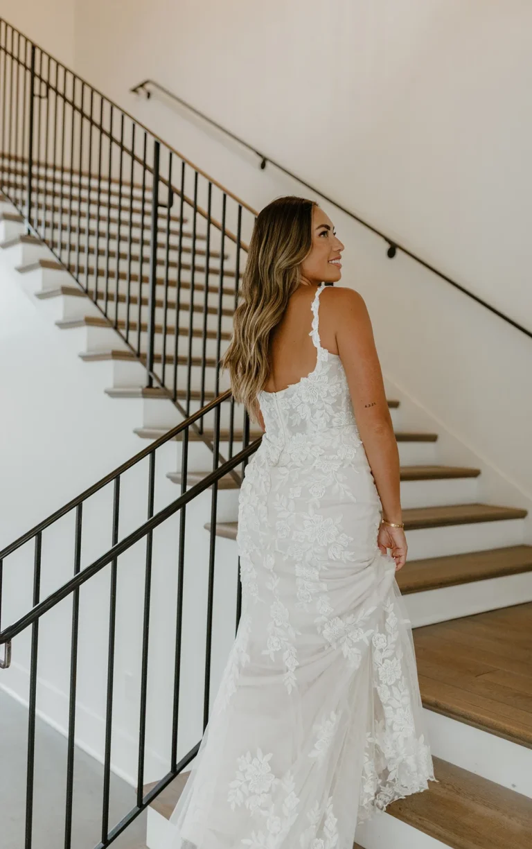 Elegancka koronkowa suknia ślubna typu fit & flare z kwiatowym motywem i ramiączkami