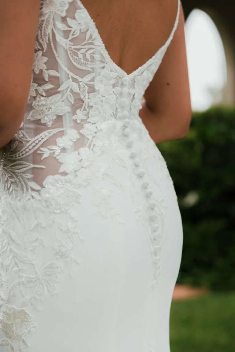 Elegancka koronkowa suknia ślubna typu fit & flare na cienkich ramiączkach z wycięciem i trenem